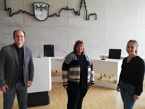 Drei kommunale Mitarbeitende aus dem Projektteam von "Bildung integriert" vor dem Hintergrund des Sitzungssaals im Lahn-Dill-Kreis